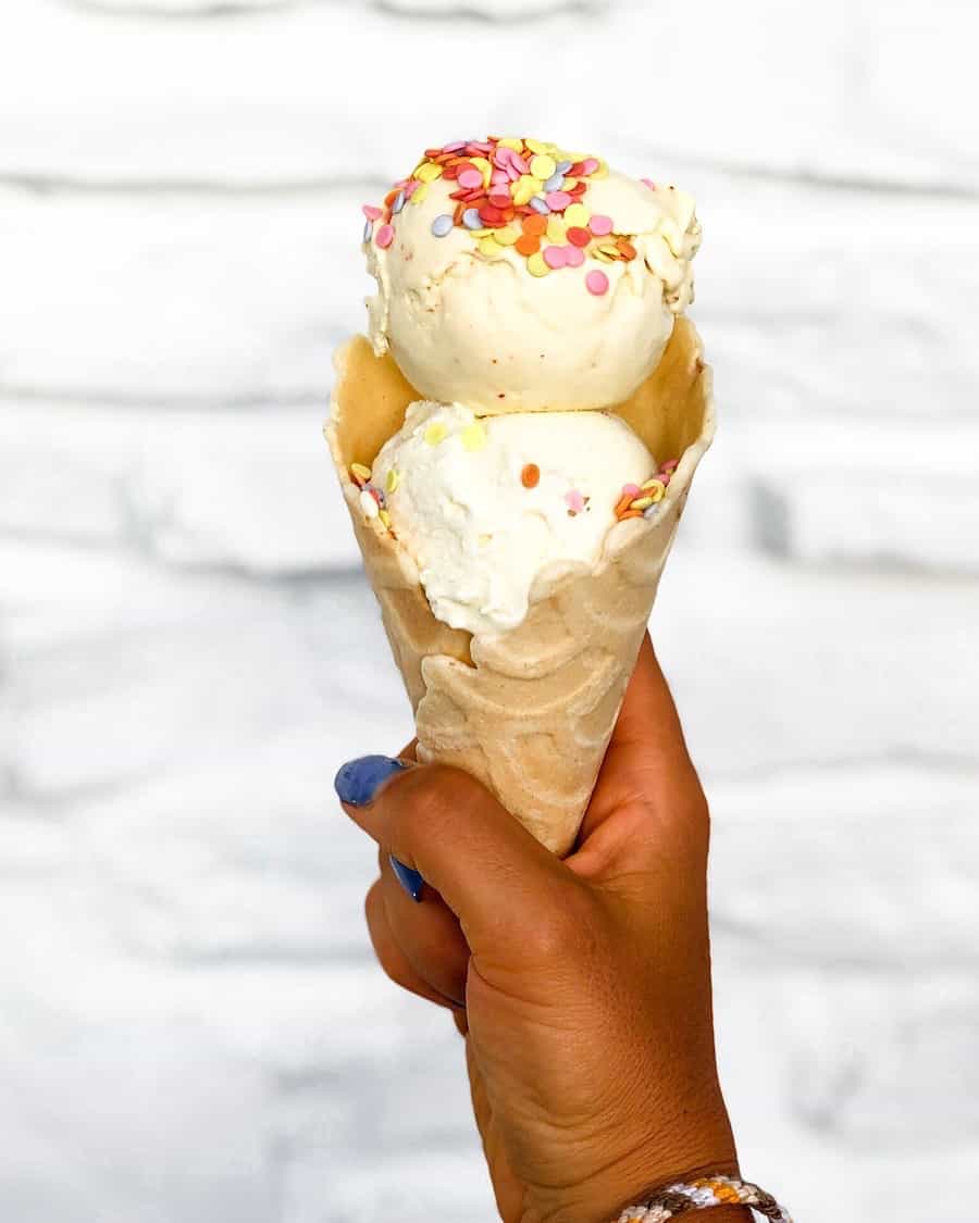 Waffle ice cream cone filled with 2 scoops of ice cream and sprinkles on it
