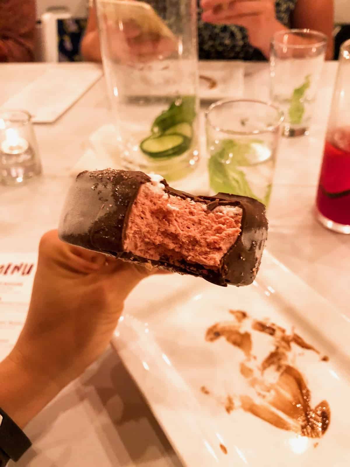 The inside of a beet and ginger ice cream bar showing the pink beet ice cream