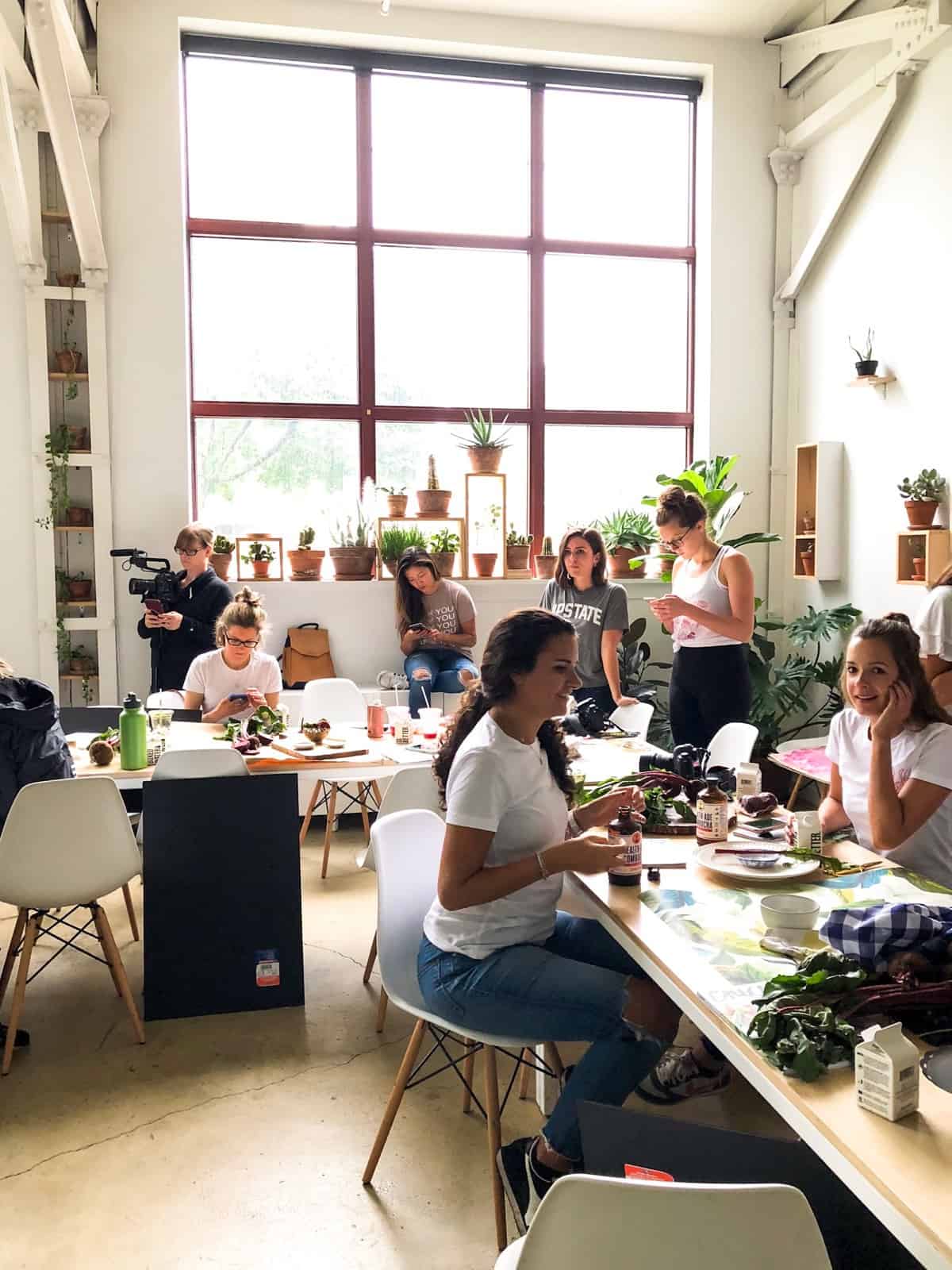 The inside of the Rochester Brainery - big open space with large windows, tables and chairs, and plants