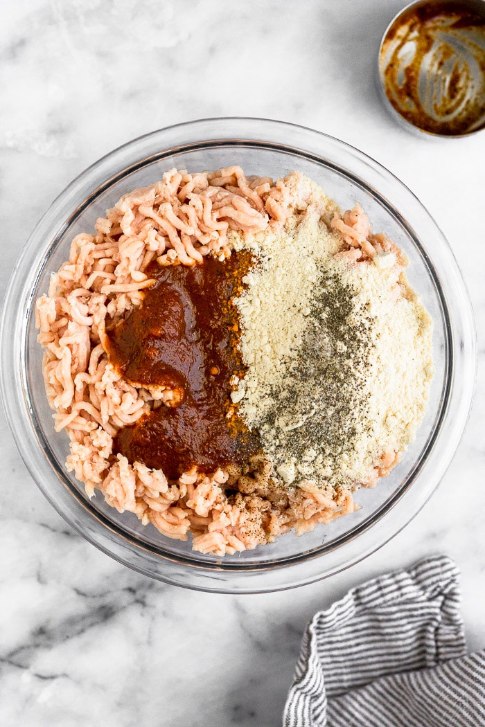 Bowl of ground chicken, bbq sauce, coconut flour, and salt and pepper.