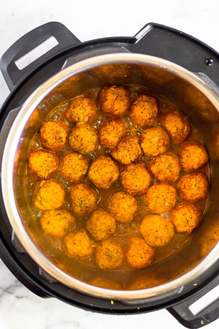Chicken meatballs in instant pot sautéing with BBQ sauce.