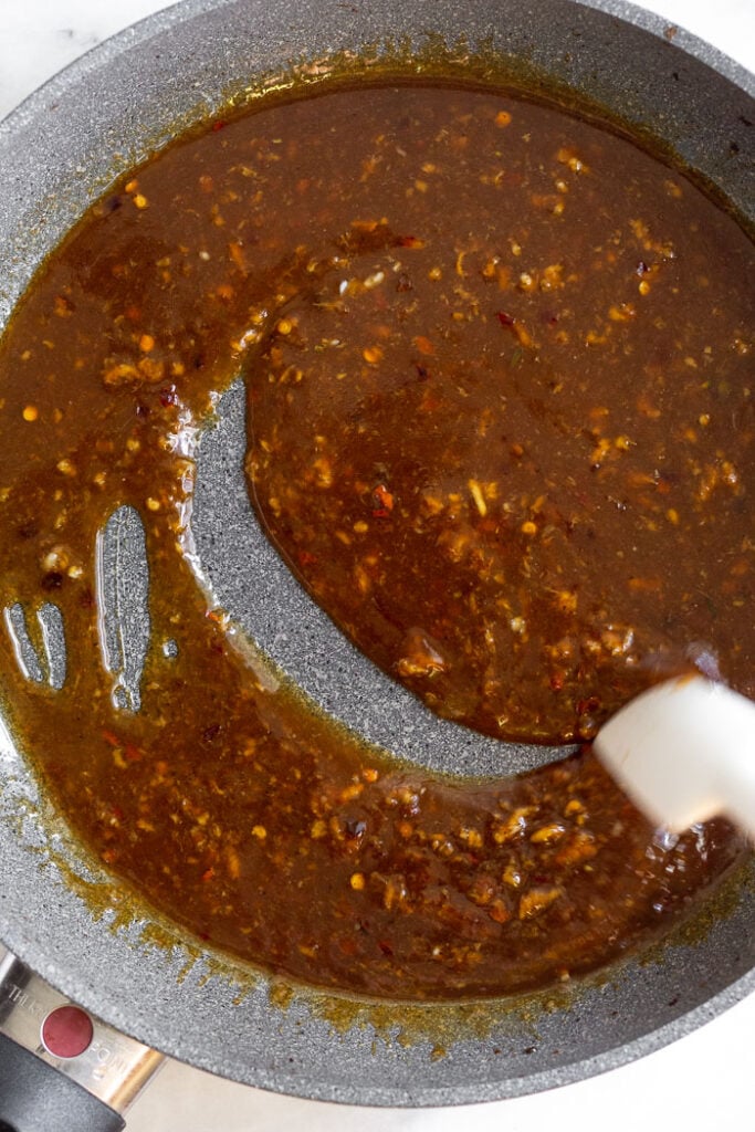 Beef and broccoli sauce in a saute pan with a spatula running through it.