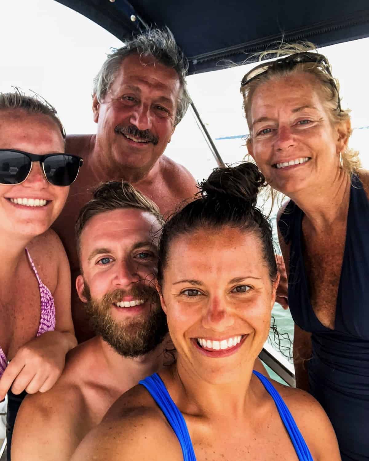 A family on a boat - a dad, mom, 2 sisters, and one of the sister's fiancé
