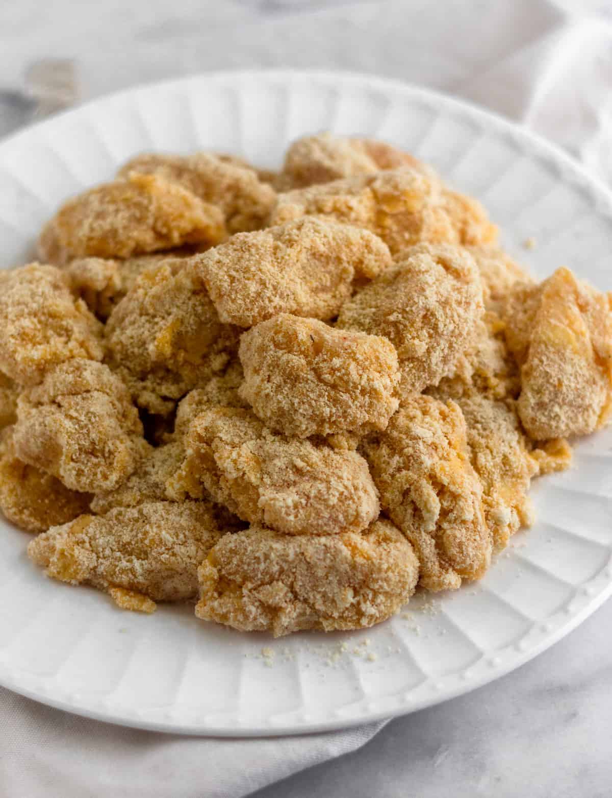 Plate of raw chicken that is breaded in almond flour and tapioca flour