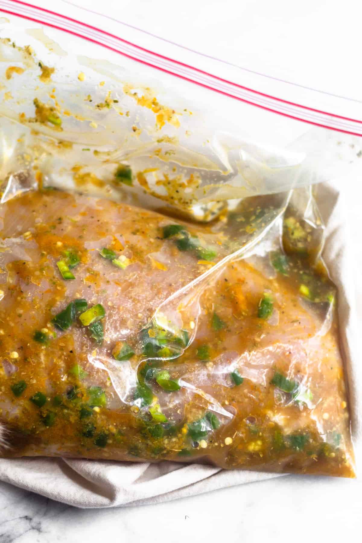 A turkey breast in a bag sitting in a spicy citrus marinade