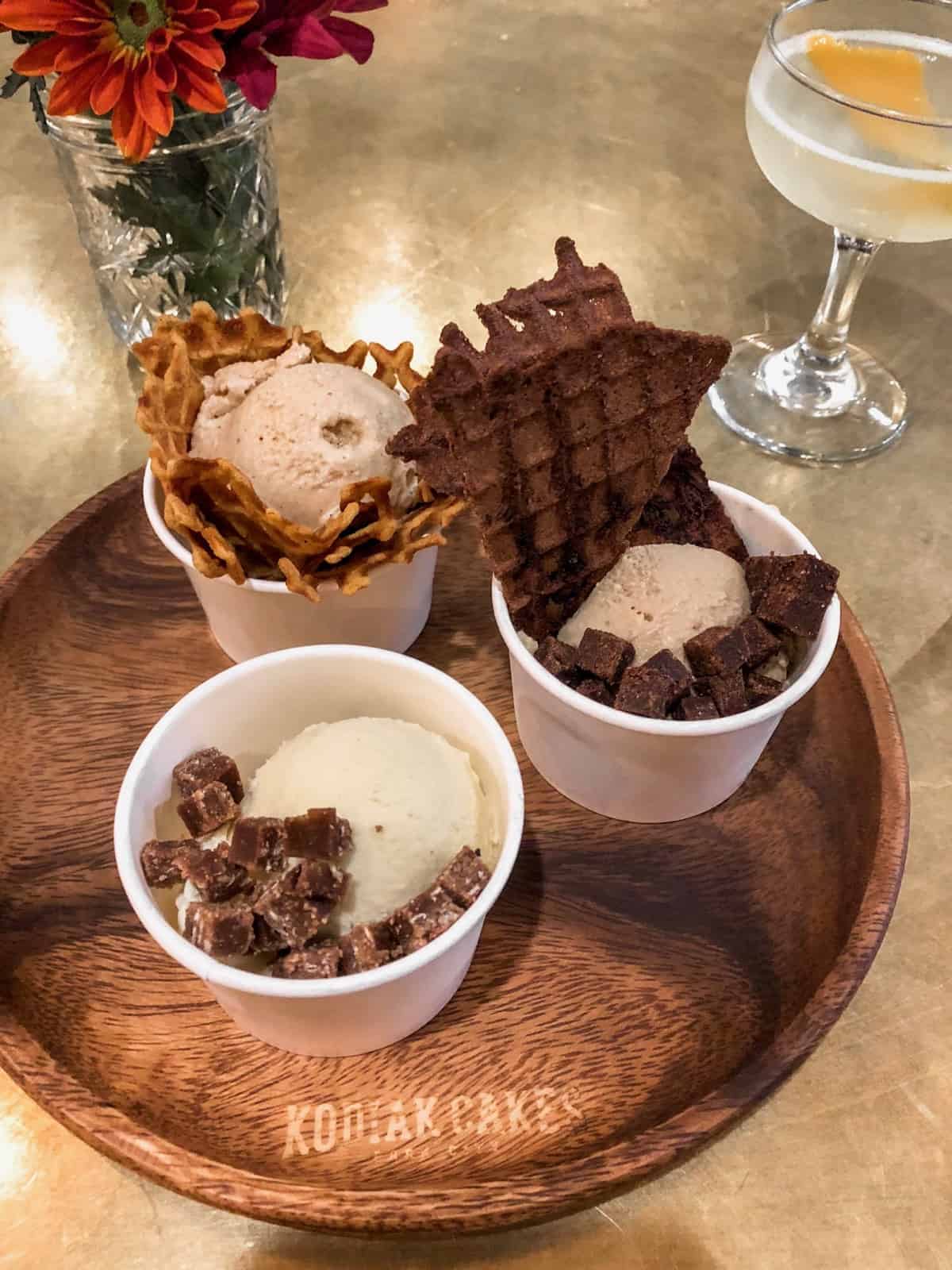 Ice cream flight in individual cups on a wooden plate