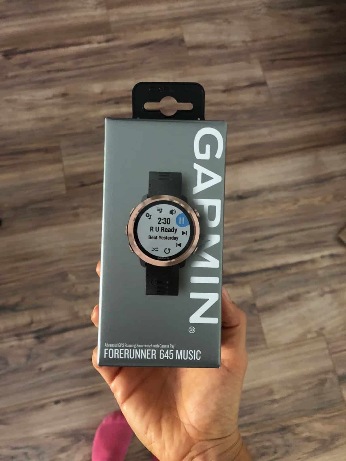 Un-open box of a Garmin Forerunner 645. The watch is black and gold.