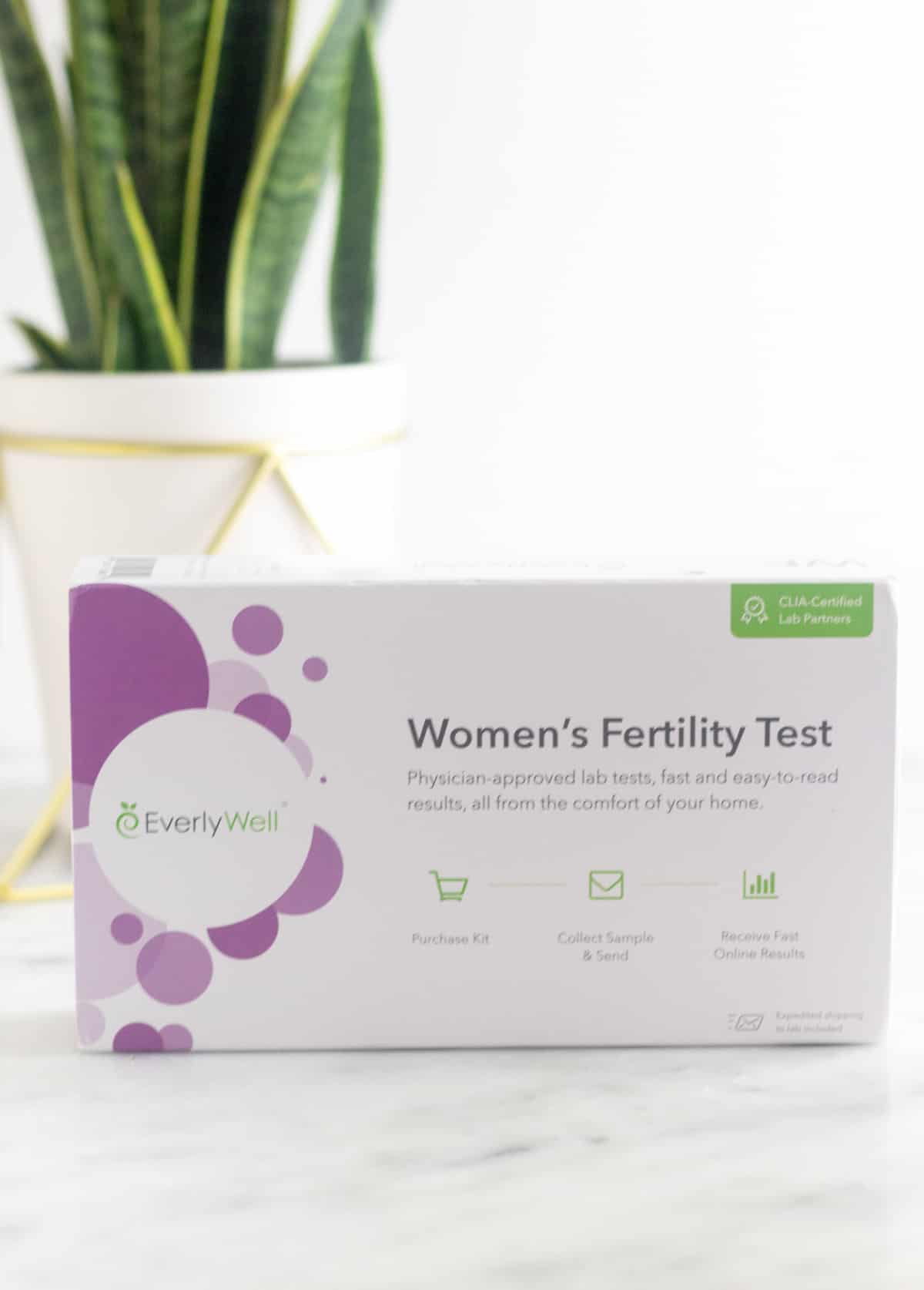 Women's Fertility Testing at Home with EverlyWell box with a plant behind it