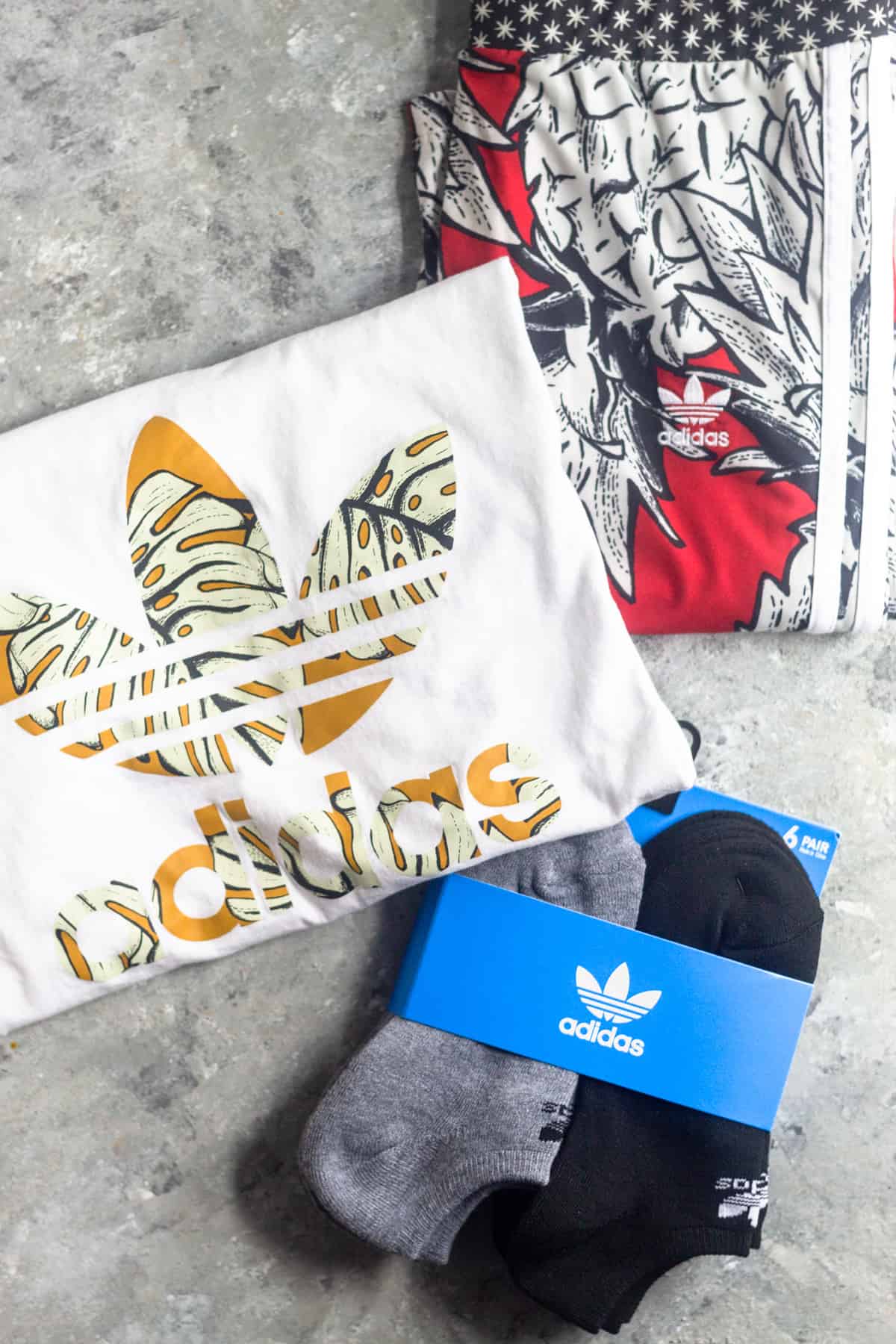 Adidas leggings, an Adidas shirt, and Adidas socks on a grey surface