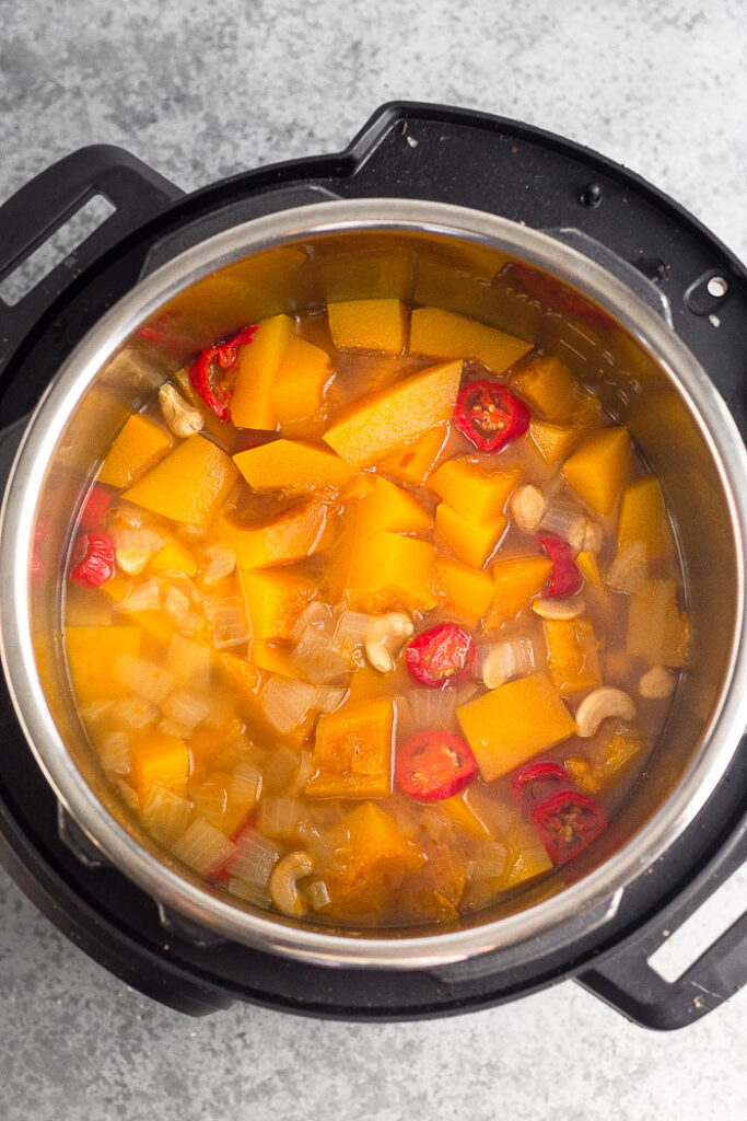 Instant Pot filled with cooked vegan pumpkin soup before it is blended.