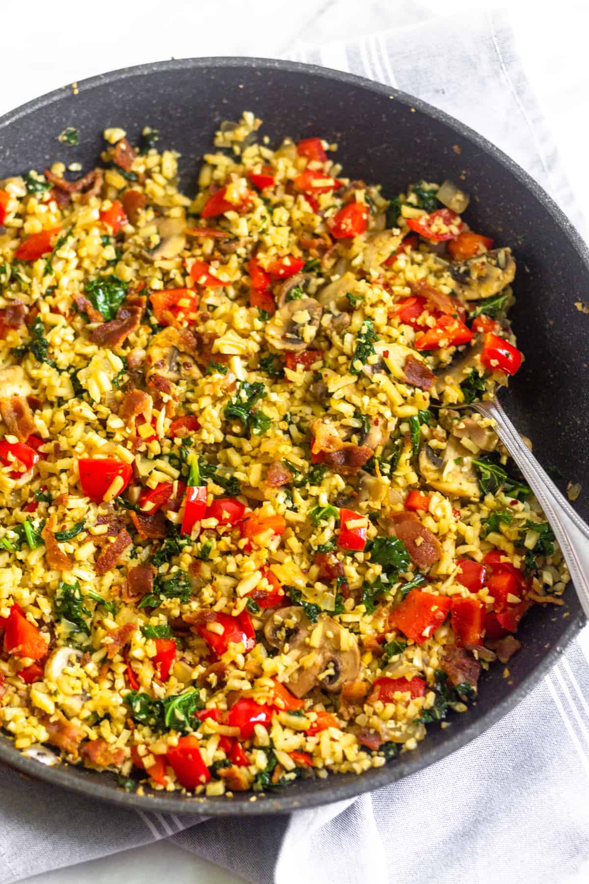 Pan filled with paleo breakfast fried rice with a spoon coming out of it