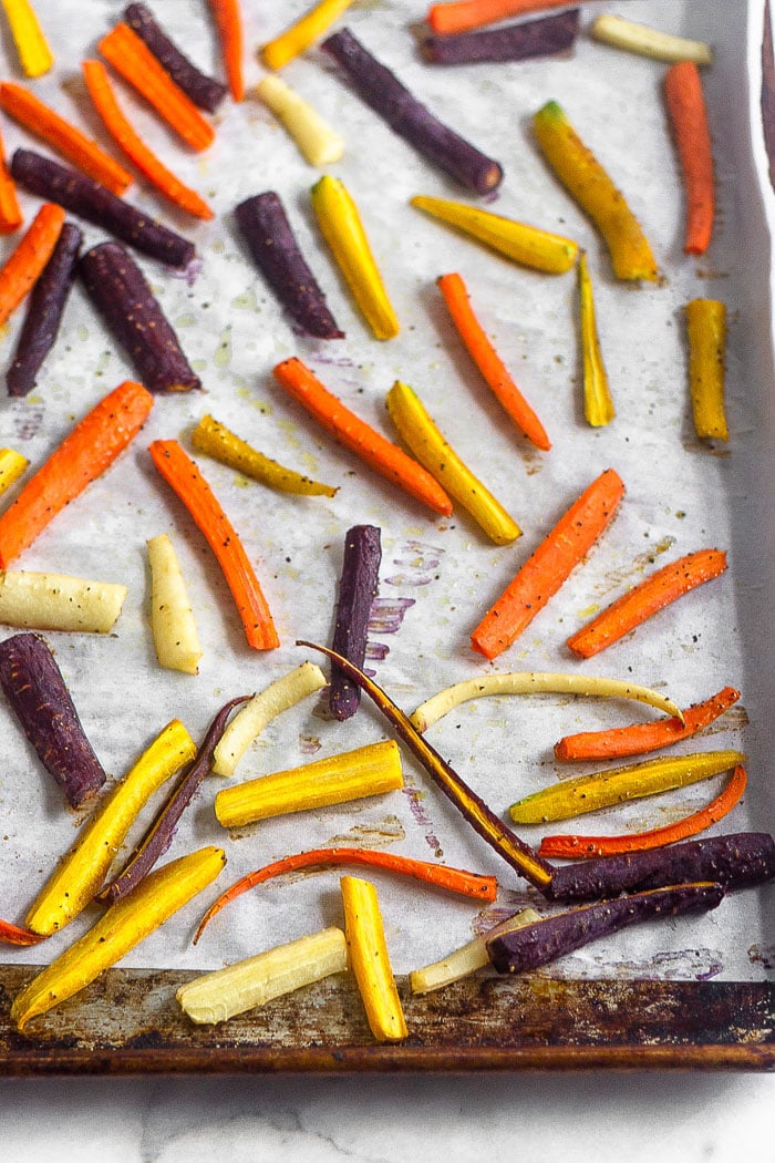 Baking sheet filled with rainbow roasted carrots.