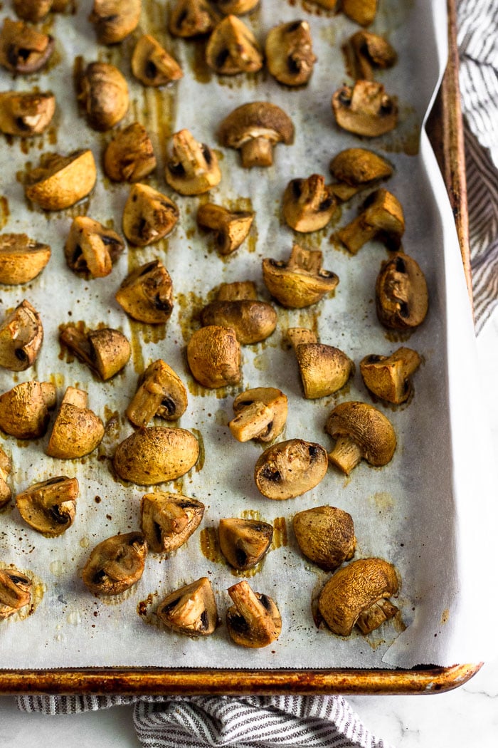 Baking sheet filled with oven roasted mushrooms.