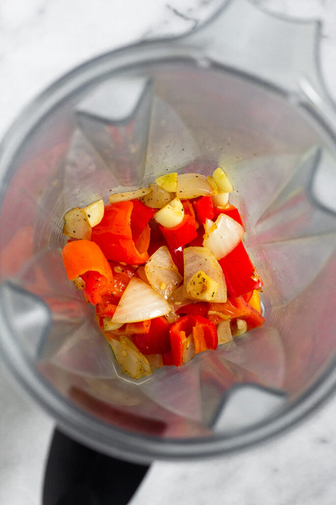 Blender filled with sautéed pepper, onions, and malice in it.