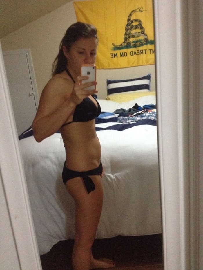 Girl in a bikini taking a selfie from the side in the mirror