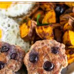 A plate of two homemade breakfast sausages, fried eggs, and roasted sweet potatoes on greens.