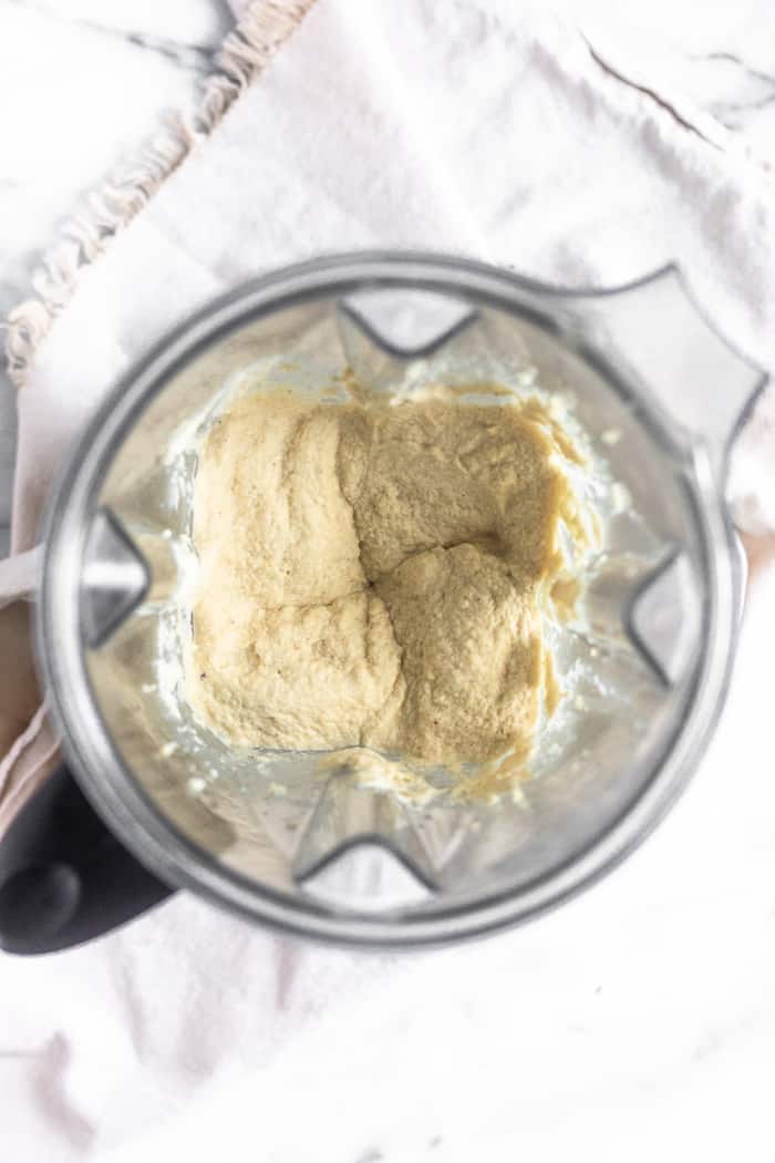 A Vitamix filled with paleo cauliflower hummus after it is blended all the way to give it a creamy consistency.
