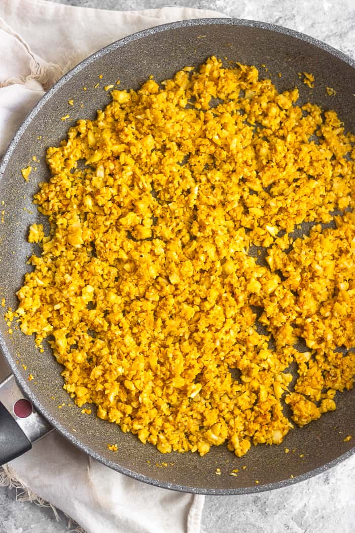 Large skillet filled with coconut curry cauliflower rice.