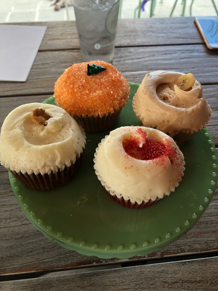 Cake stand filled with 4 different cupcakes with different icings.
