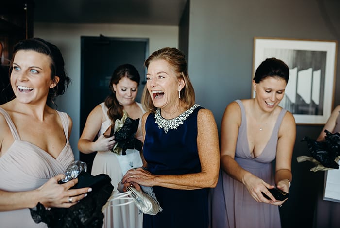 A mother laughing as her daughter is getting ready for her wedding.