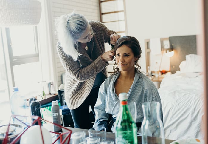 A bride getting her hair done on her wedding day.