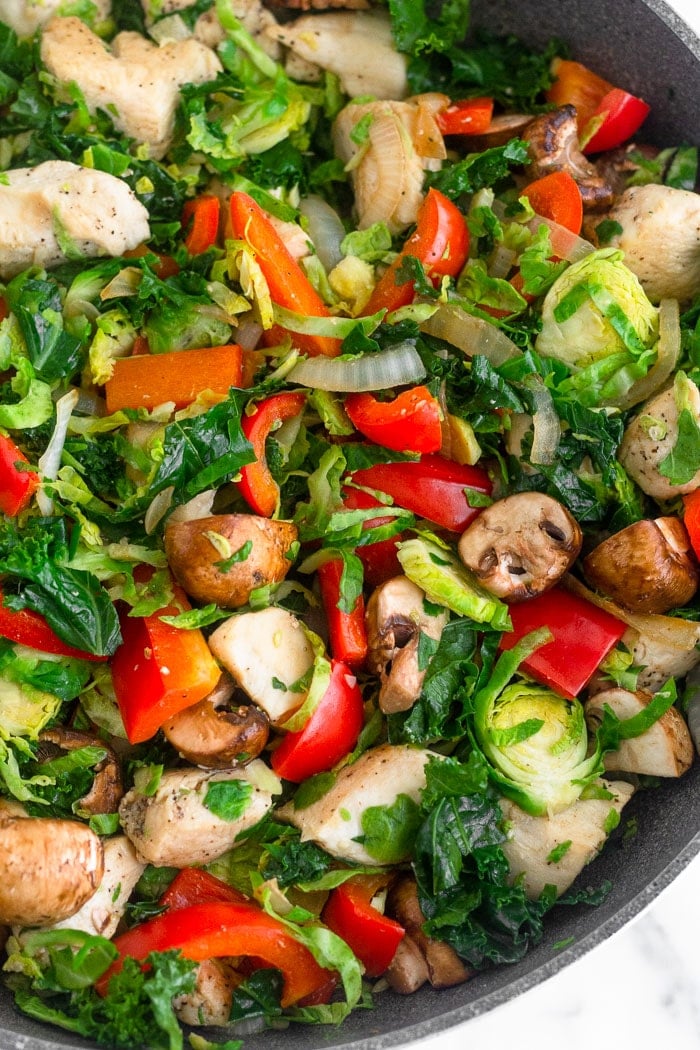 Large skillet filled with sautéed chicken and veggies.