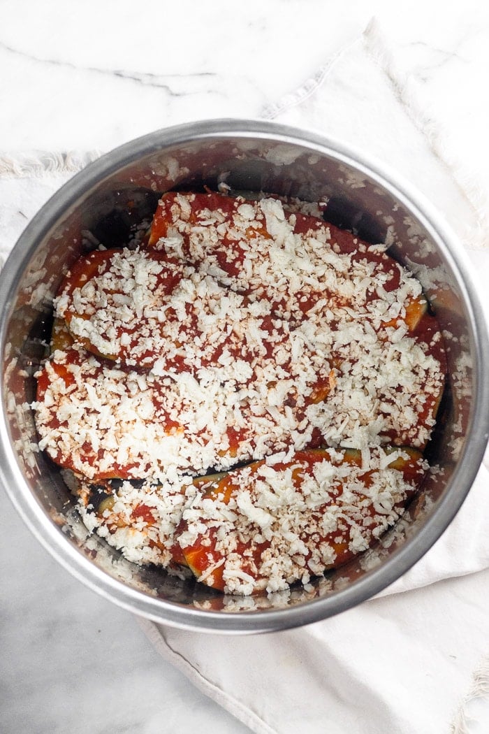 Healthy instant pot eggplant parmesan in the Instant pot before it is cooked. Layers of eggplant are topped with sauce and cheese.