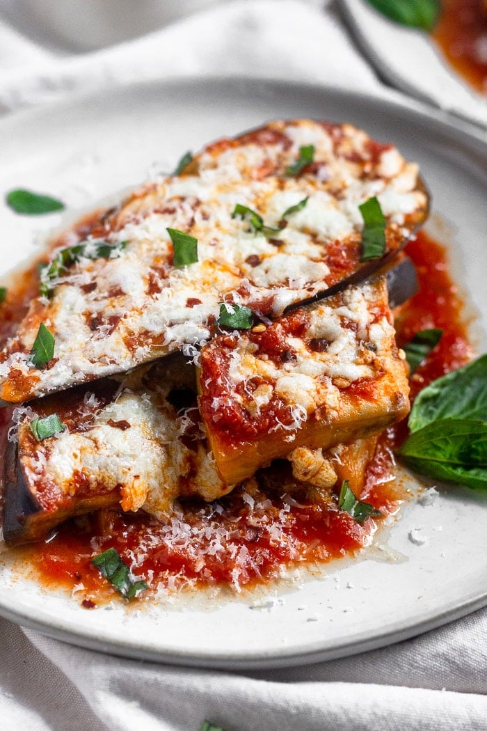 Healthy instant pot eggplant parmesan without breadcrumbs topped with fresh basil, parmesan cheese, and red pepper flakes.