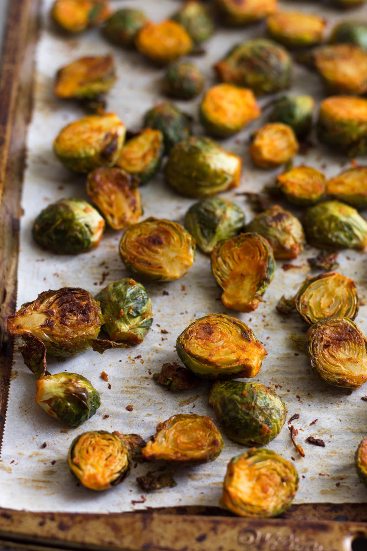Baking sheet filled with roasted buffalo Brussels sprouts,