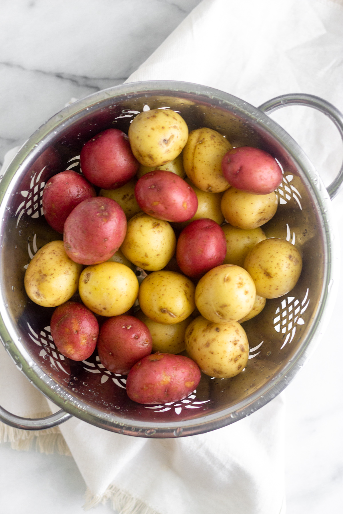Large colander filled with baby potatoes.