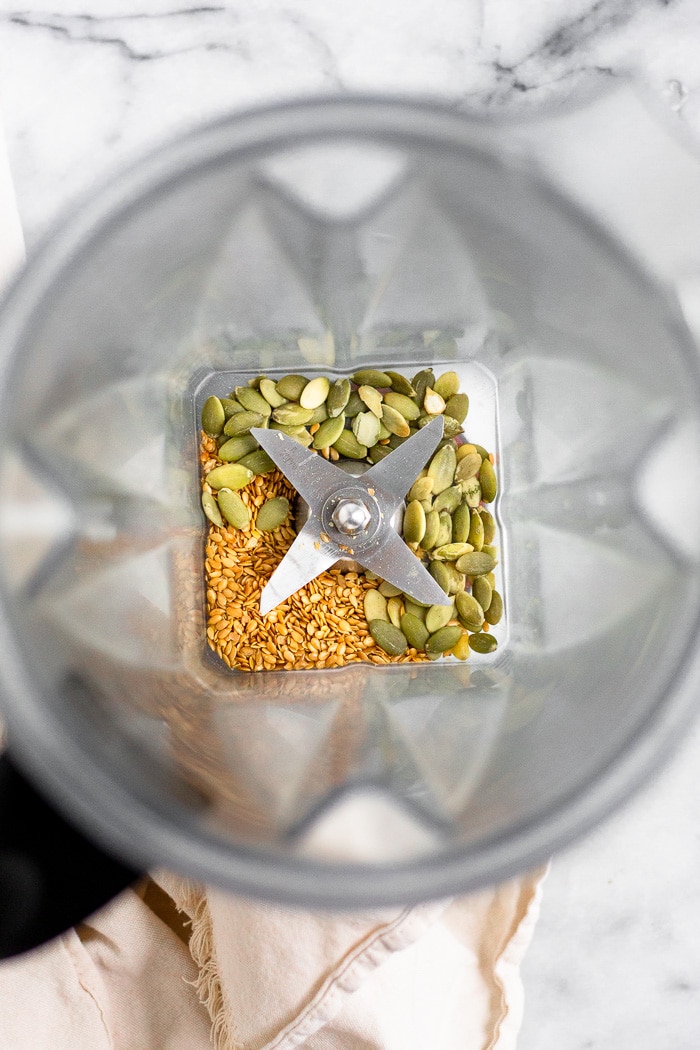 Blender filled with flax and pumpkin seeds for seed cycling.