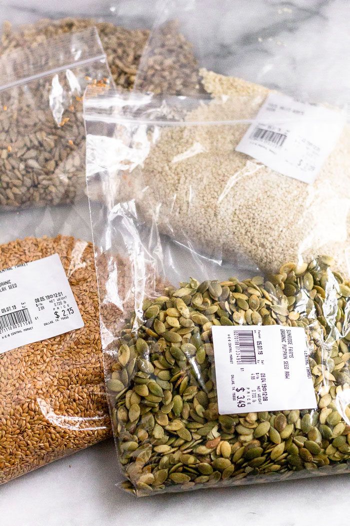 4 large plastic bags, each filled with different seeds (sunflower, sesame. pumpkin, and flax).