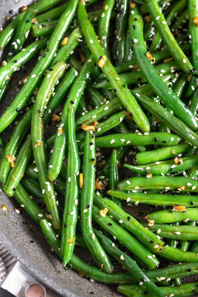 Close up of sesame green beans in a large skillet.