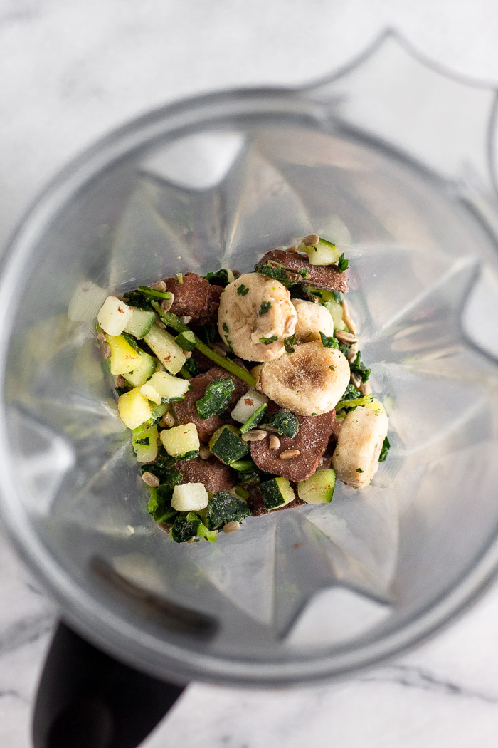 Frozen fruits and veggies inside a blender.