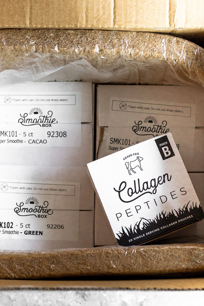An open delivery of Smoothie Box with 4 different flavors and a box of collagen peptides.