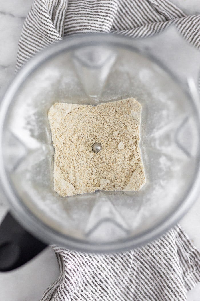 Blender filled with rolled oats that have been ground down into oat flour.