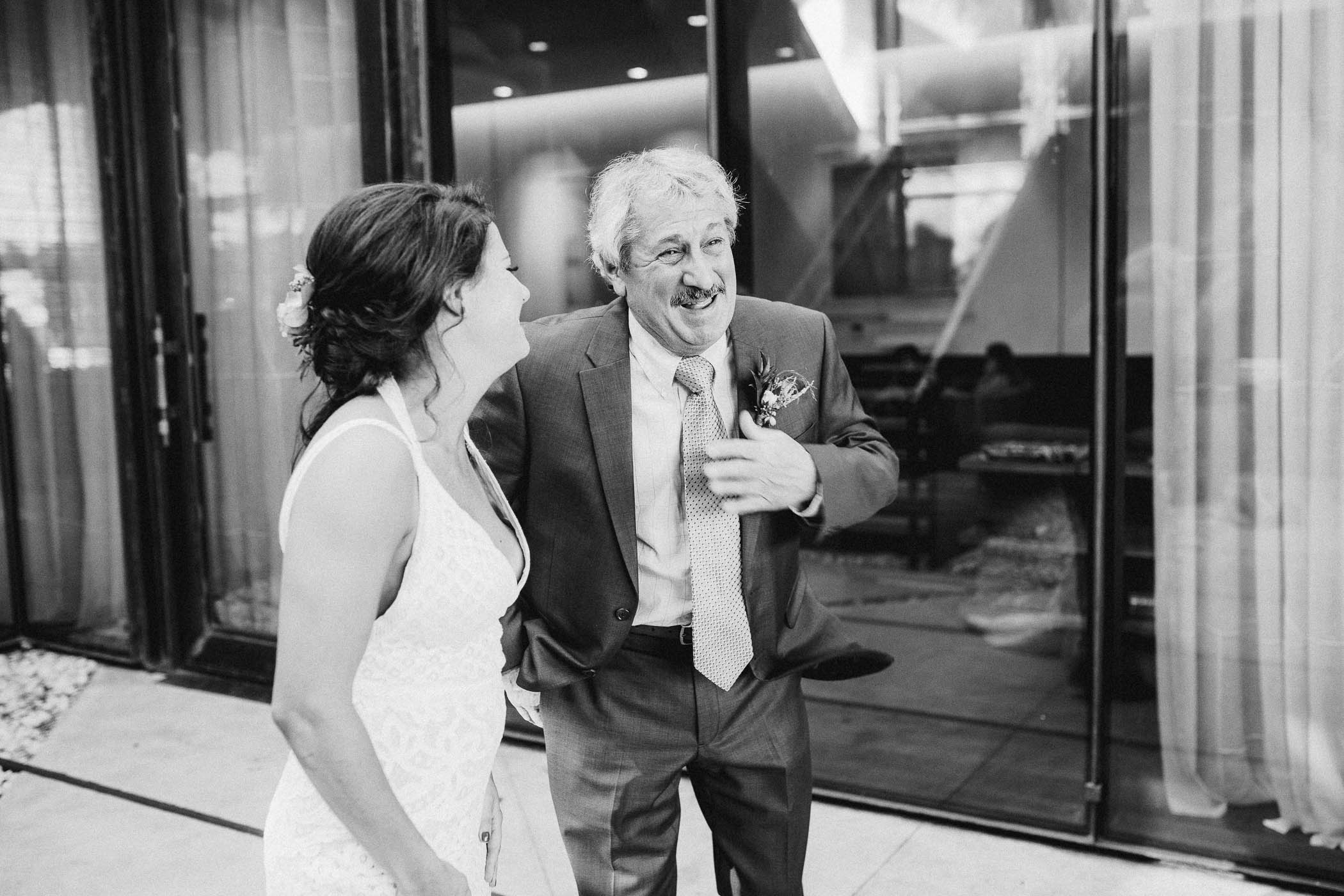 Father and daughter laughing on her wedding day.