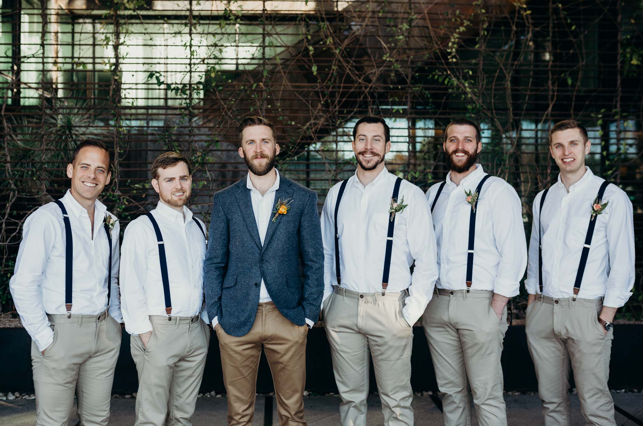 The groom and groomsmen. They are all wearing khakis and the groomsmen have white shirts and suspenders while the groom is wearing a blue jacket.