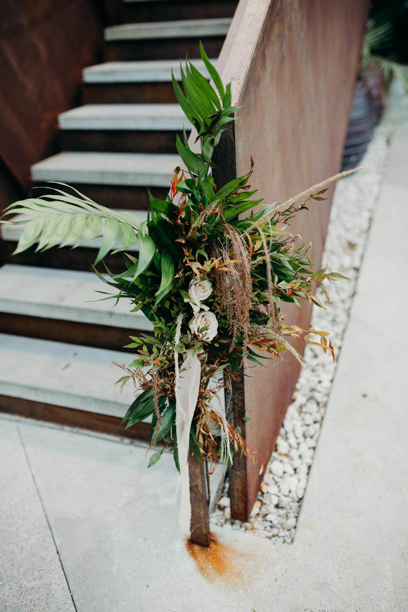 Flowers and greens tied on a stairway.