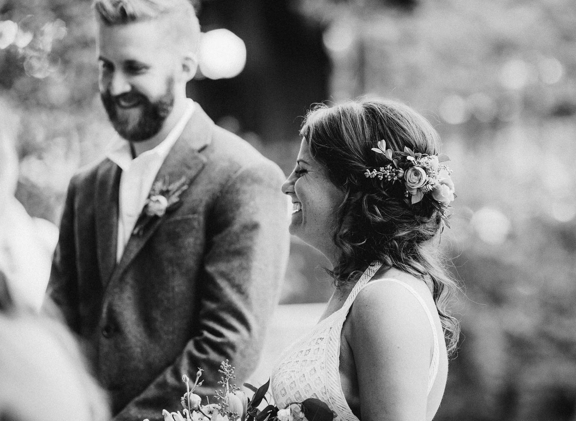 Bride and groom at the alter on their wedding day. They are both laughing.
