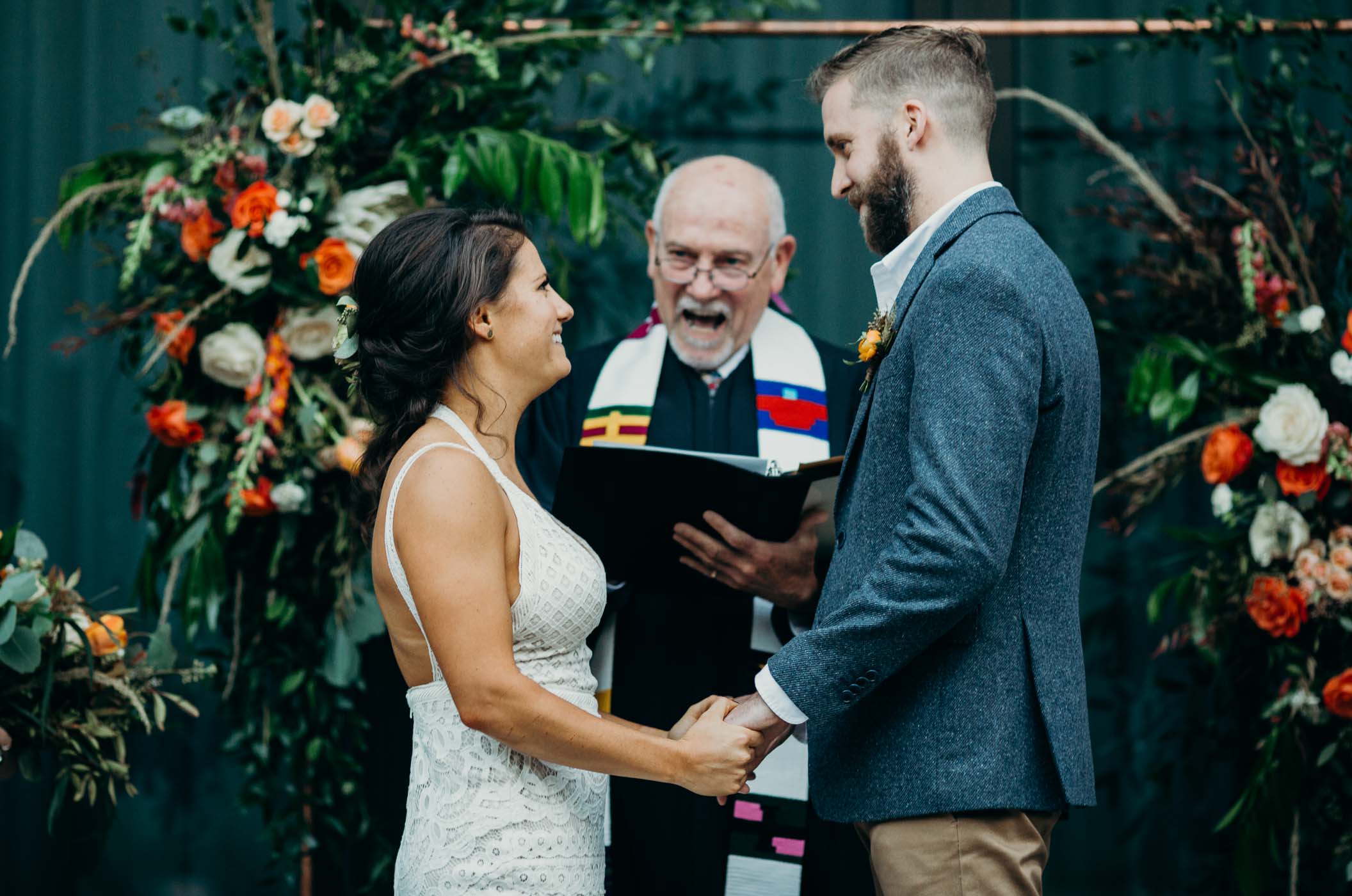 Bride and groom holding hands at the alter about to get married.