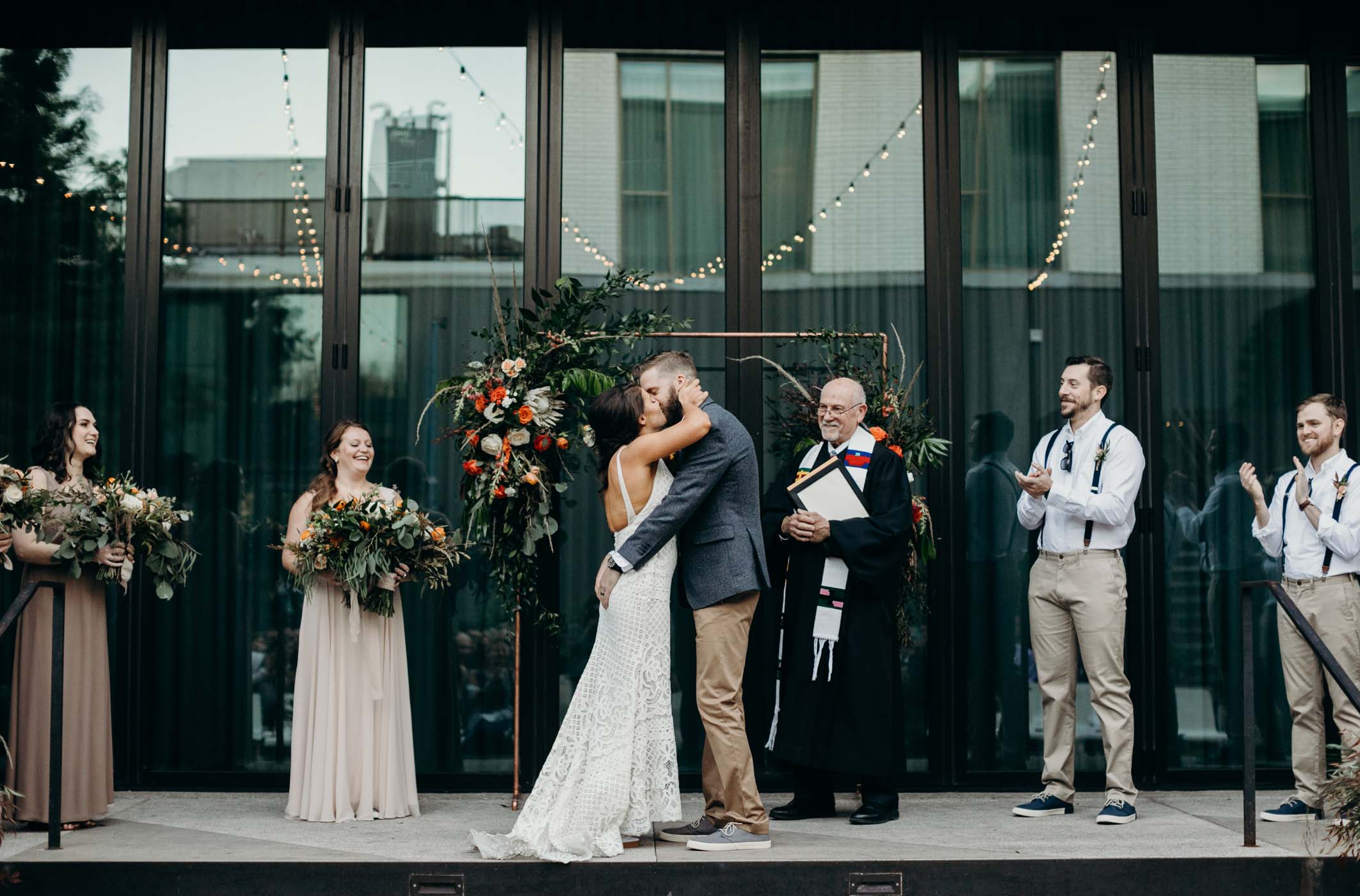Bride and groom kissing at the alter after they were married. The groom is grabbing the brides butt.