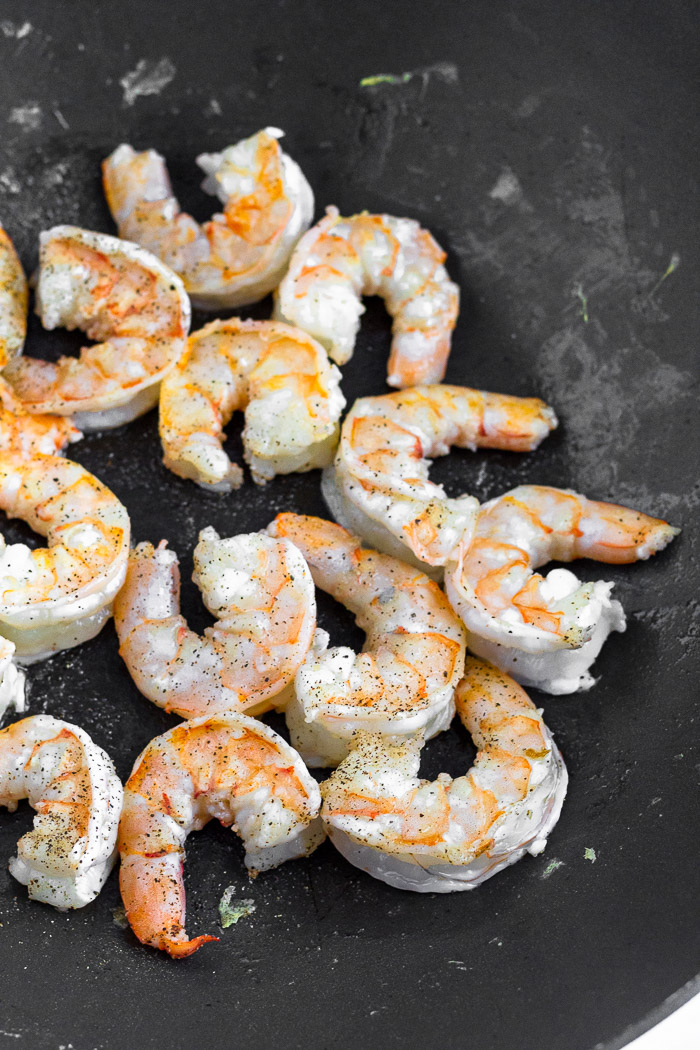 Wok with cooked shrimp in it.