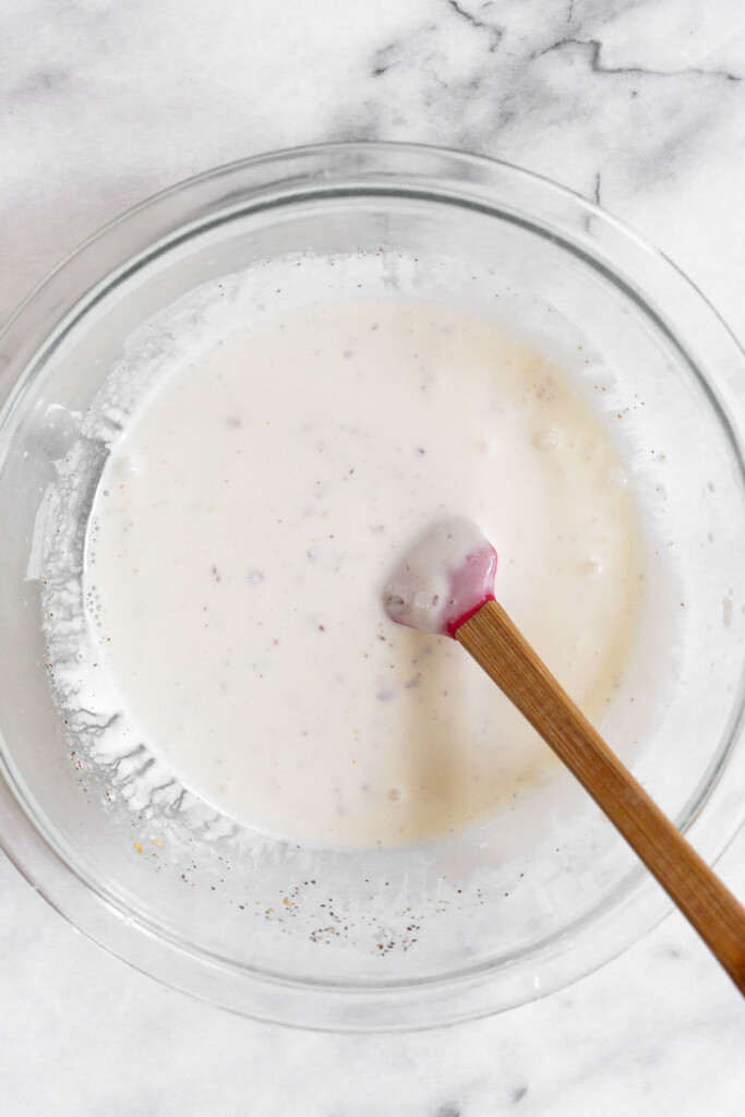 A large bowl with a greek yogurt mixture and a spatula in it.