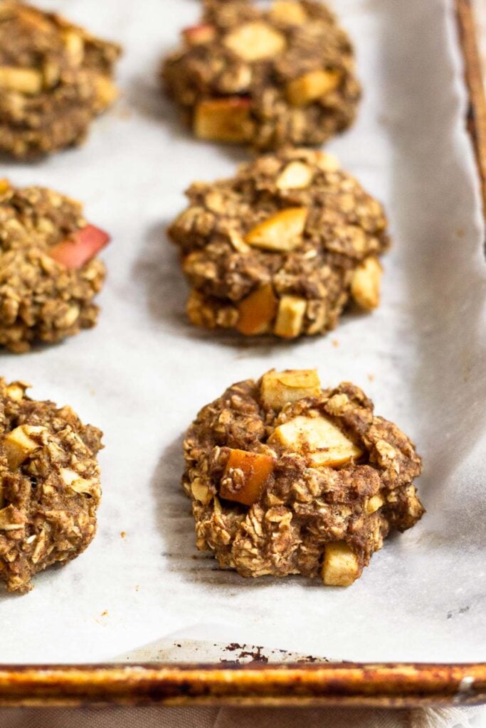Apple cinnamon protein cookies on a baking sheet lined with parchment paper.