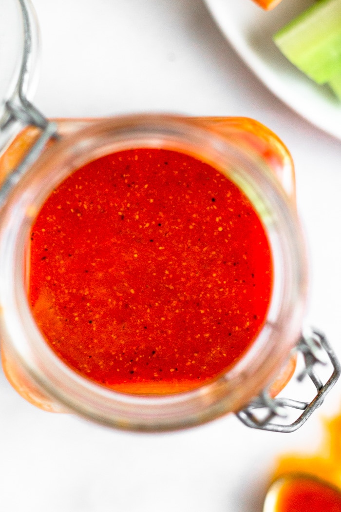 Overhead shot of a small jar filled with the best buffalo sauce