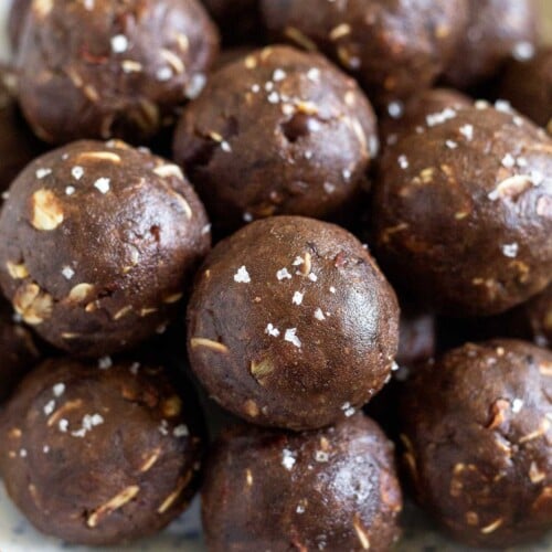 A bowl of chocolate peanut butter protein balls. They are sprinkled with sea salt.