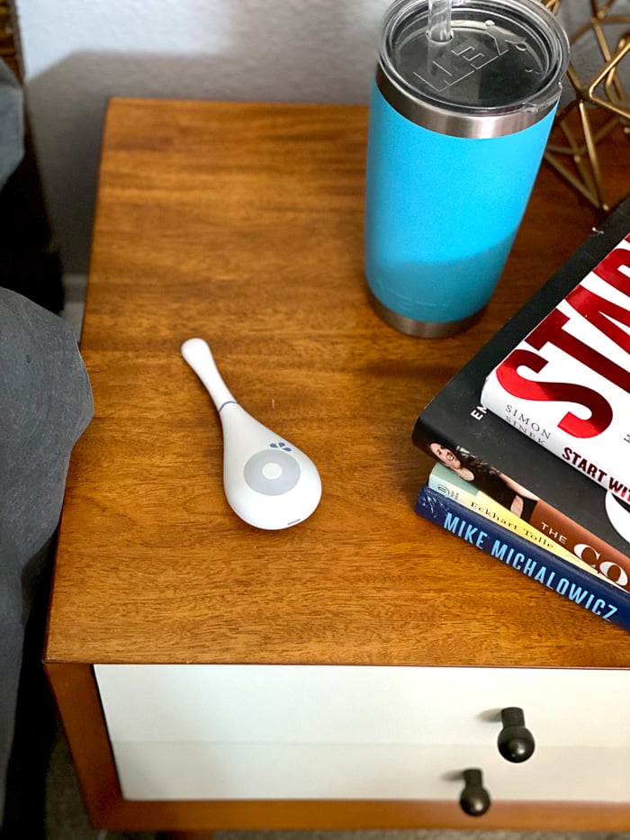 Daysy fertility tracker on a nightstand with a keto and a stack of books.