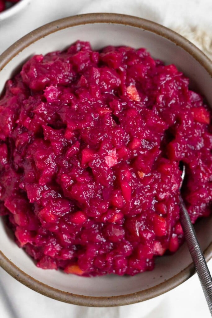 Overhead shot of a bowl of sugar free cranberry sauce with a spoon in it.
