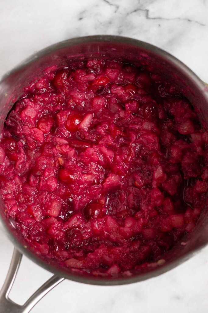 A pot of cranberries and pineapple that has been cooked down some.
